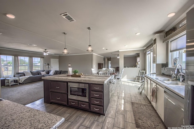 kitchen featuring a sink, stainless steel appliances, crown molding, dark brown cabinetry, and visible vents