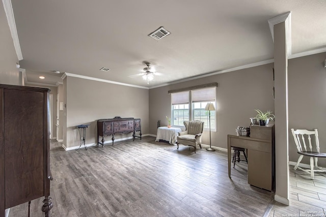 sitting room featuring visible vents, a ceiling fan, and crown molding