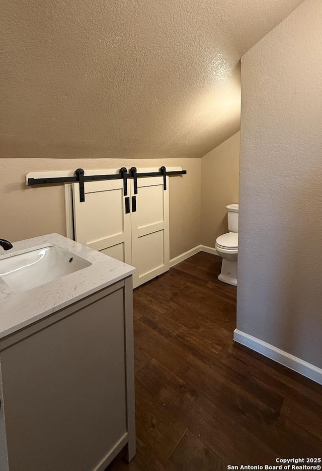 7274 Fm 327, Elmendorf, TX 78112 - laundry room featuring baseboards, laundry area, a barn door, a sink, and dark wood-style floors