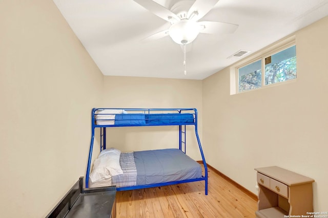 bedroom featuring baseboards, visible vents, a ceiling fan, and wood-type flooring