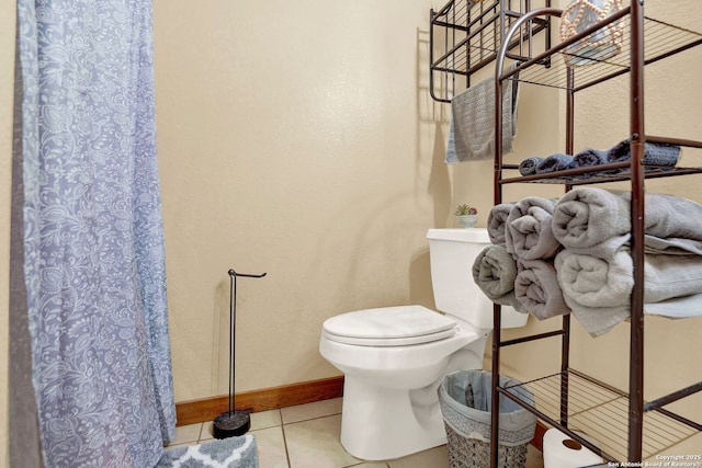 bathroom with toilet, tile patterned flooring, and baseboards