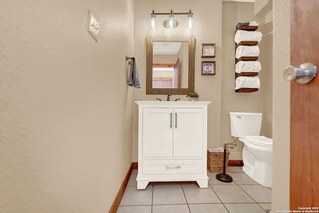 half bathroom featuring baseboards, toilet, tile patterned flooring, and vanity