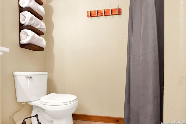 bathroom with baseboards, a shower with curtain, toilet, and tile patterned flooring