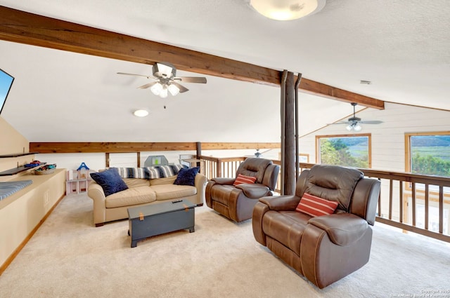 carpeted living area with lofted ceiling with beams and a ceiling fan