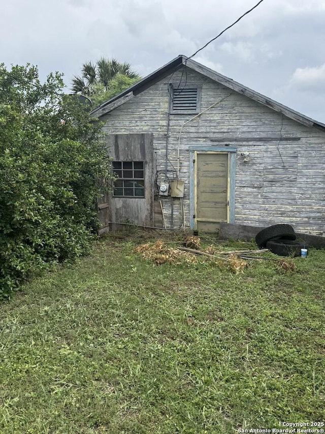 back of house with a lawn