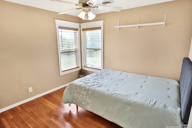 bedroom featuring wood finished floors, visible vents, and baseboards
