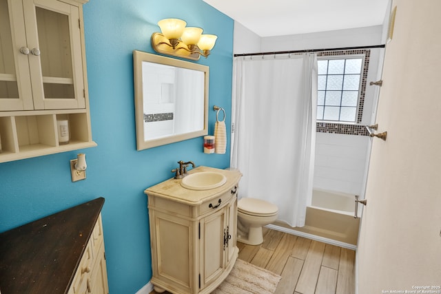 bathroom with toilet, wood finished floors, vanity, and shower / bath combo