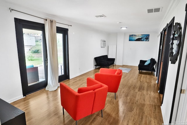 living area featuring visible vents, wood finished floors, and baseboards