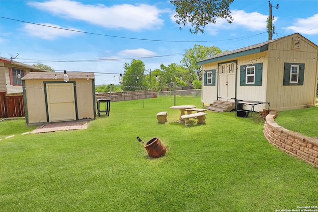 view of yard with fence private yard, entry steps, and an outbuilding