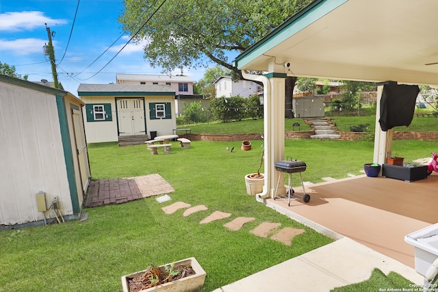 view of yard with an outdoor structure, a storage shed, a patio area, and fence
