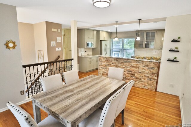 dining area featuring baseboards and light wood-type flooring