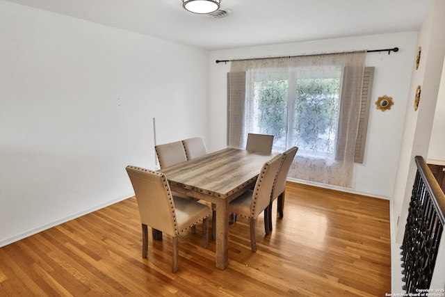 dining room featuring visible vents, light wood-type flooring, and baseboards