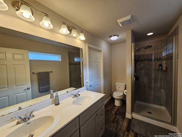 943 Patton, San Antonio, TX 78237 - bathroom featuring a sink, a shower stall, wood finished floors, and visible vents