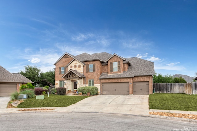 view of front of property featuring a front yard, brick siding, roof with shingles, concrete driveway, and fence