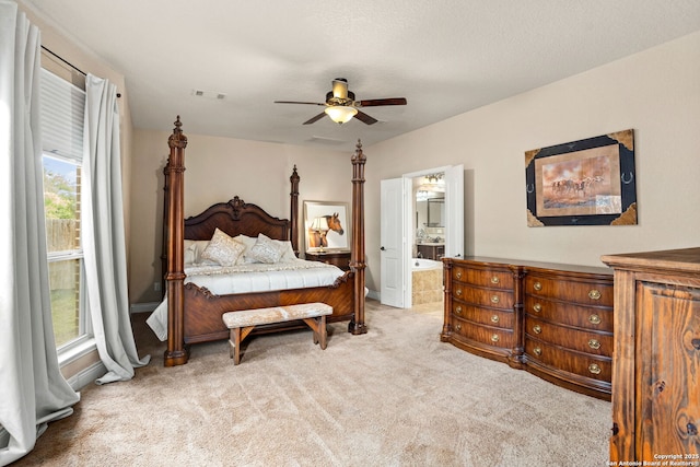 carpeted bedroom featuring baseboards, visible vents, ceiling fan, and ensuite bath