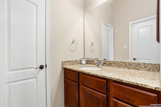 bathroom featuring a textured wall and vanity