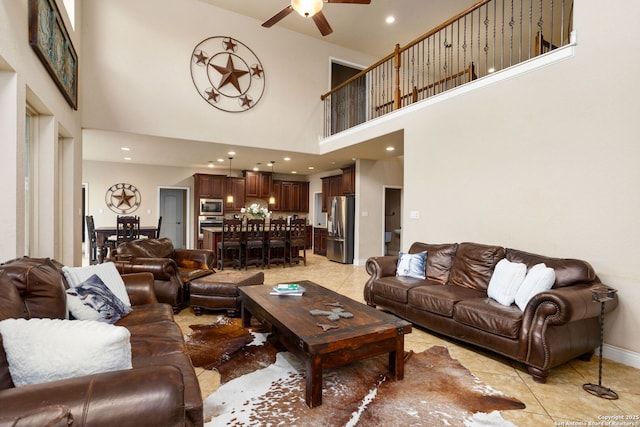 living room featuring a high ceiling, recessed lighting, light tile patterned flooring, and a ceiling fan