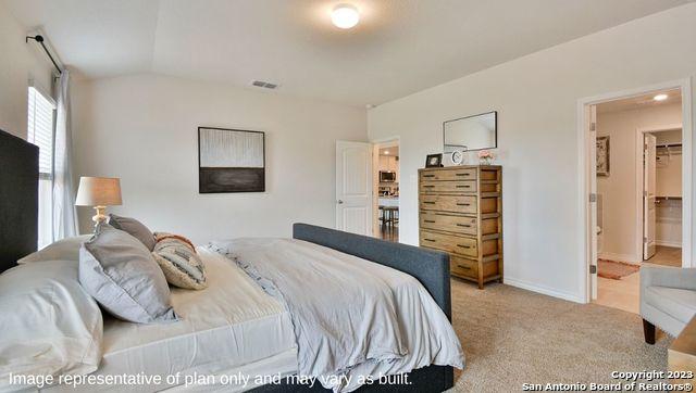 bedroom featuring visible vents, vaulted ceiling, light colored carpet, and baseboards