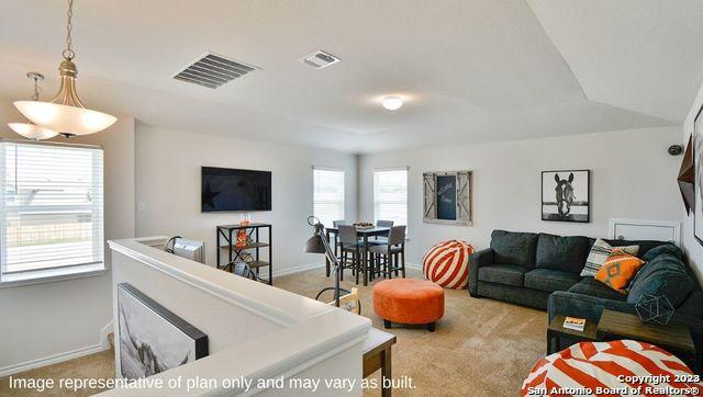 living room featuring light colored carpet, visible vents, and baseboards
