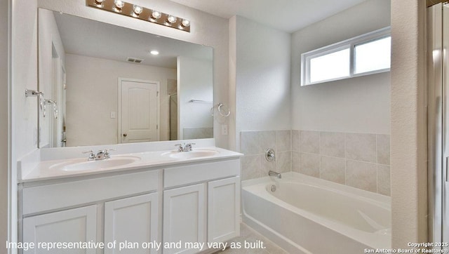 bathroom featuring a bath, double vanity, a sink, and visible vents
