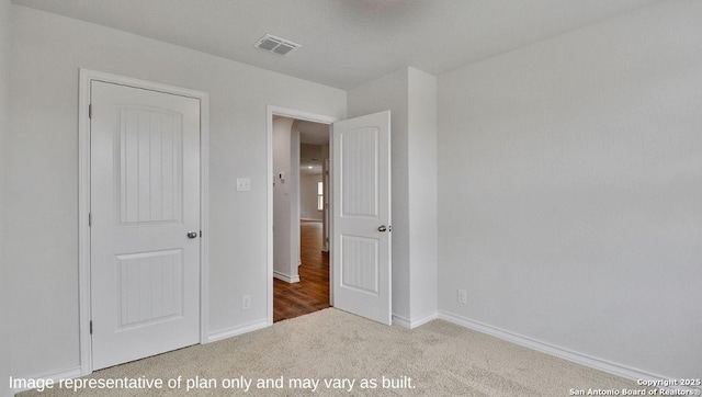 unfurnished bedroom with visible vents, carpet floors, and baseboards
