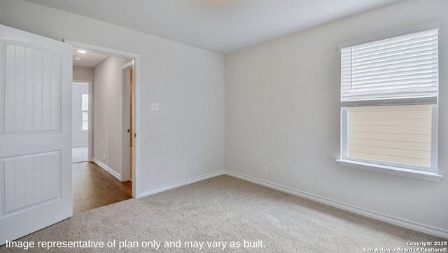 carpeted spare room featuring baseboards