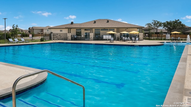 pool with fence and a patio