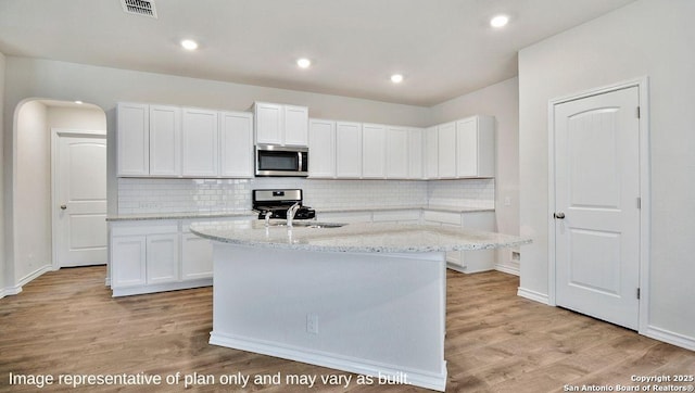 kitchen featuring appliances with stainless steel finishes, tasteful backsplash, visible vents, and light wood-type flooring