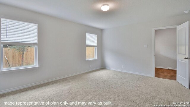 carpeted empty room with baseboards