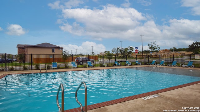 pool with fence and a patio