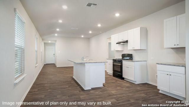 5055 Wichita Pike, San Antonio, TX 78253 - kitchen with dark wood-style flooring, white cabinetry, black range with gas stovetop, and under cabinet range hood
