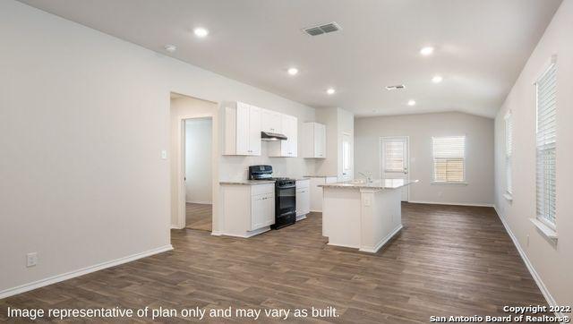 5055 Wichita Pike, San Antonio, TX 78253 - kitchen with dark wood-type flooring, a center island with sink, visible vents, white cabinetry, and gas stove