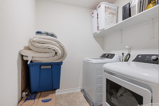 washroom featuring washer and dryer, laundry area, and baseboards