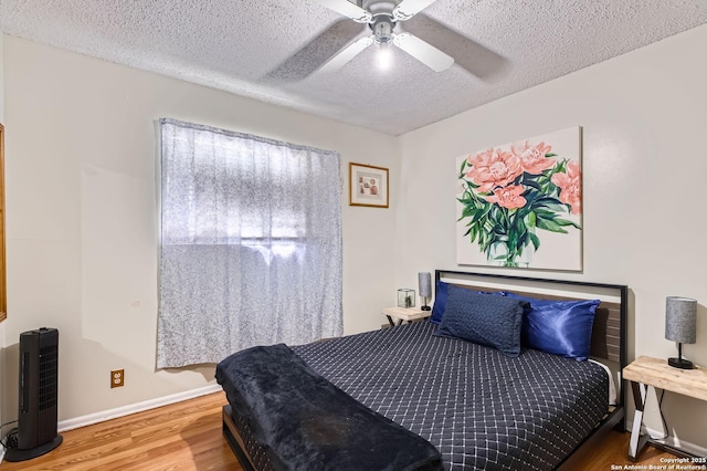 bedroom with baseboards, a ceiling fan, a textured ceiling, and wood finished floors