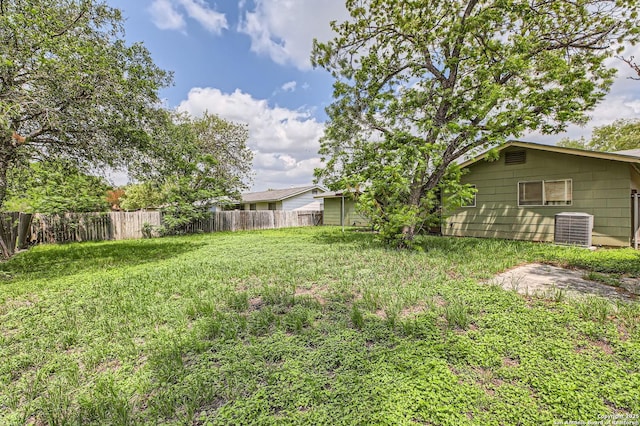 view of yard featuring fence and central AC