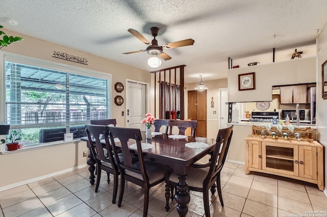 dining space with a ceiling fan, a textured ceiling, a healthy amount of sunlight, and light tile patterned flooring