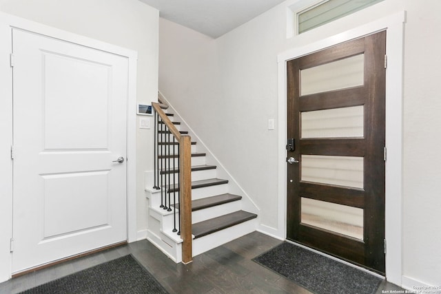 entryway featuring dark wood-style flooring, stairway, and baseboards