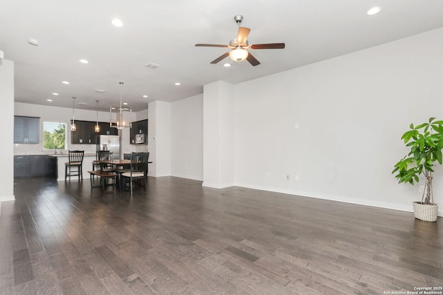 living room with baseboards, recessed lighting, ceiling fan, and dark wood-type flooring