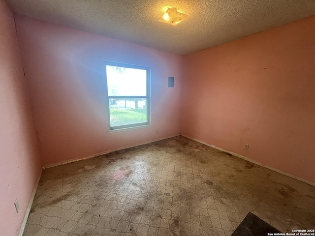 7322 Goya, San Antonio, TX 78239 - empty room with tile patterned floors, baseboards, and a textured ceiling