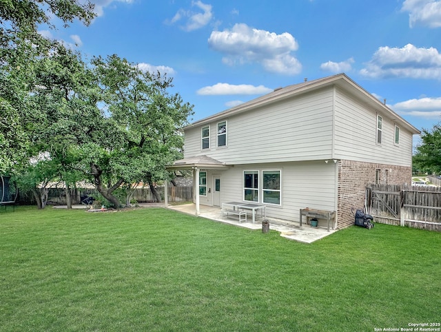 rear view of house featuring a patio, a lawn, and a fenced backyard