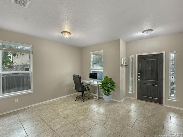 interior space featuring a textured ceiling, visible vents, and a healthy amount of sunlight