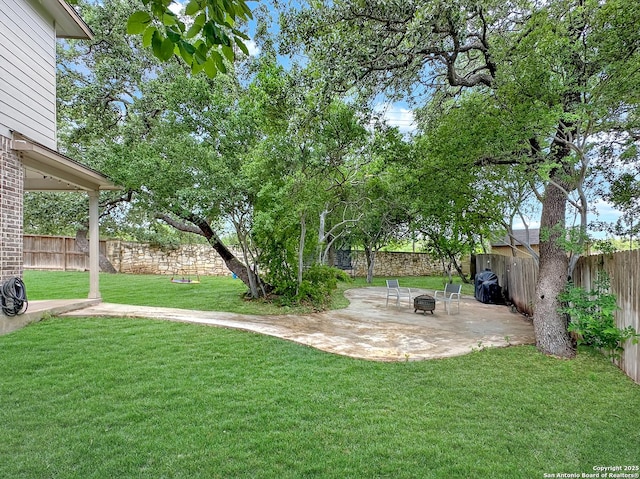view of yard featuring a patio, an outdoor fire pit, and a fenced backyard