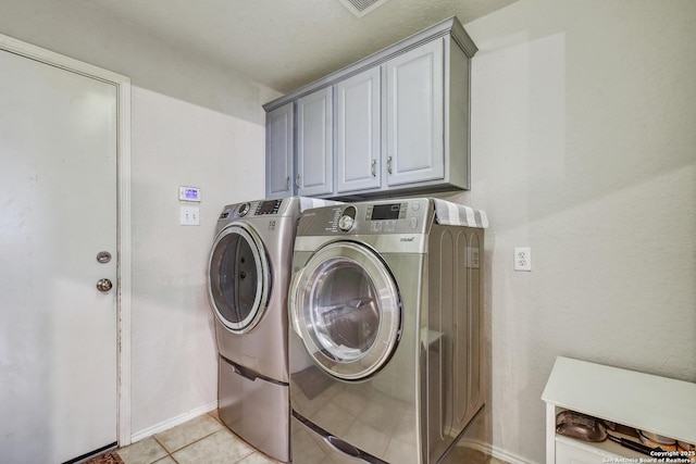 19538 Azure Oak, San Antonio, TX 78258 - laundry area featuring baseboards, cabinet space, light tile patterned flooring, and washing machine and clothes dryer