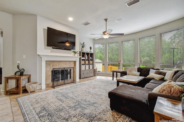 19538 Azure Oak, San Antonio, TX 78258 - living area with a tile fireplace, visible vents, and a ceiling fan