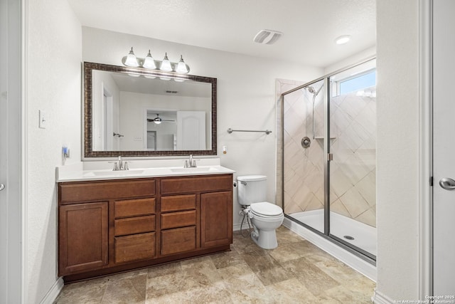 full bath with double vanity, toilet, a stall shower, and a sink