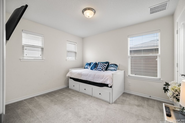 bedroom with carpet, visible vents, and baseboards