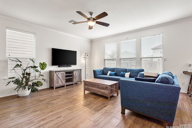 living room featuring crown molding, visible vents, ceiling fan, and light wood-style flooring