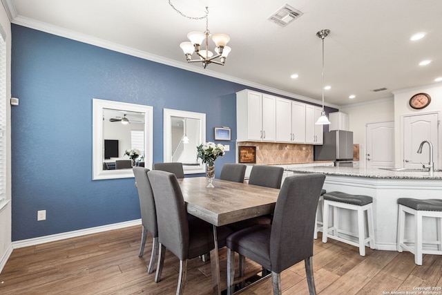 dining space with visible vents, light wood finished floors, crown molding, and recessed lighting