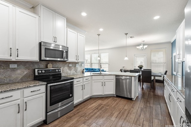 kitchen featuring a sink, dark wood-style flooring, a chandelier, stainless steel appliances, and white cabinetry