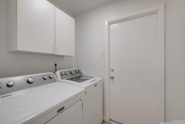 clothes washing area with washer and dryer and cabinet space